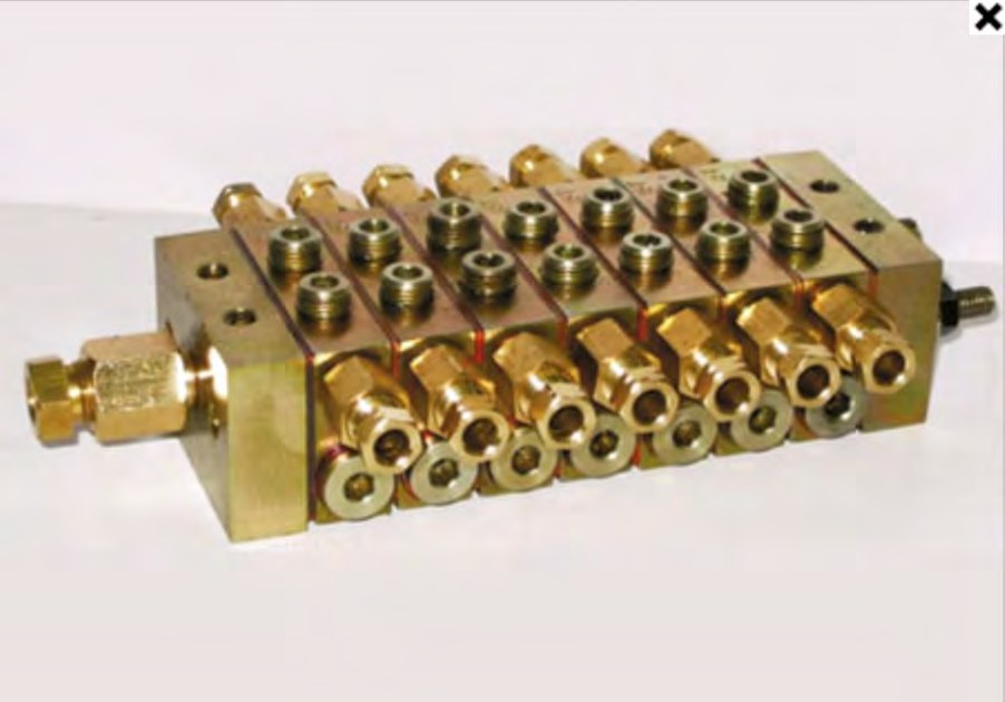 Machined hydraulic manifold block with drilled cross-bores produced from continuous cast iron bar
