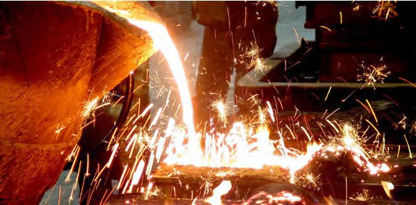 Molten iron pouring from the furnace into the treatment ladle on the continuous casting line